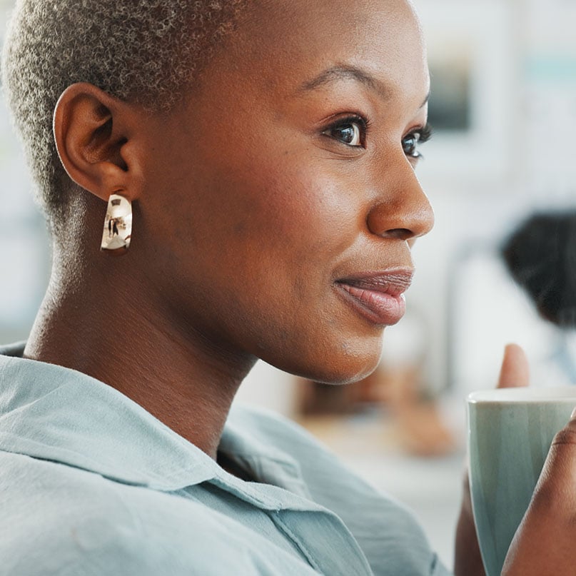 woman-looks-out-as-she-drinks-coffee