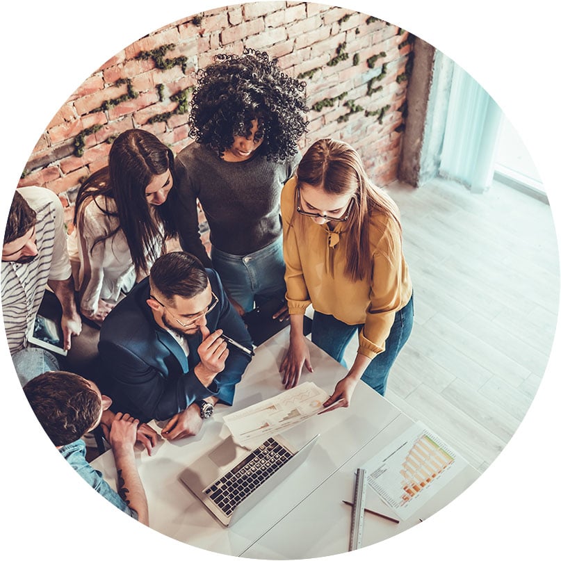 team-huddling-around-document-at-desk